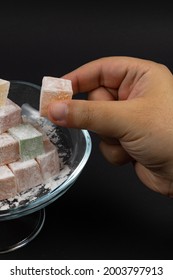 Man Taking A Turkish Delight From A Bowl On Black Background. Kurban Bayrami (eid Al Adha), Ramazan Bayrami (eid Al Fitr) Story Background Photo. Iyi Bayramlar - Eid Mubarak