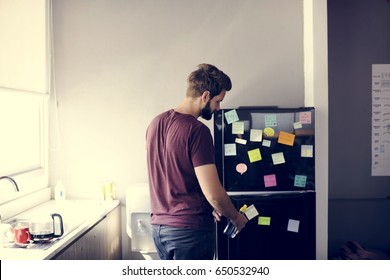 Man Taking Water Bottle From Fridge In Pantry Room During Break Time