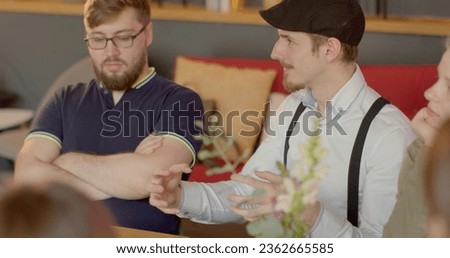 Man talking in group conversation at cafe table, expressing needs opinions, employs nonviolent communication techniques, fostering respectful dialogue. Emotional empathy training, teamwork lifestyle