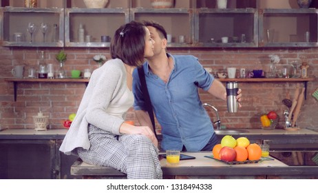 Man Talking Have Breakfast On The Kitchen With Adult Woman. Looking On The Watch And Going Fast For A Work. Happy Busy Family In Loft Modern Apartment.