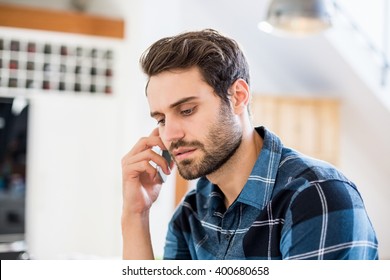 Man Talking On Mobile Phone At Home