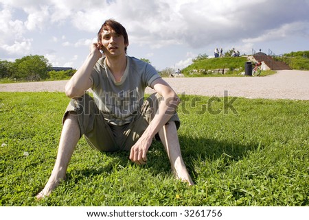 Man talking on the phone and sitting on the lawn