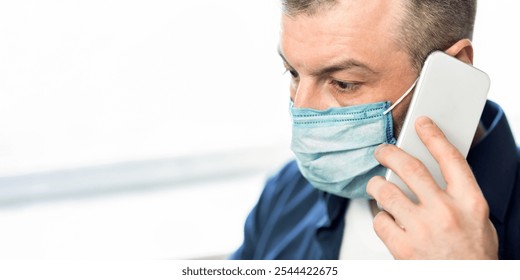 Man Talking On Phone Wearing Protective Medical Mask Standing At Home During Coronavirus Quarantine. Selective Focus, Panorama - Powered by Shutterstock