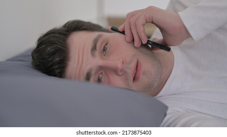 Man Talking On Phone While Sleeping In Bed, Close Up