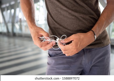 Man With Tangled Headphones. Close Up Hands