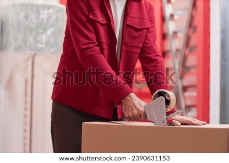 Man Taping Box in Self-Storage Unit