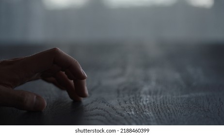 Man Tapping Fingers On Black Oak Table With Back Light, Wide Photo