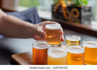 Man Tasting Beer From Flight At A Local Microbrewery