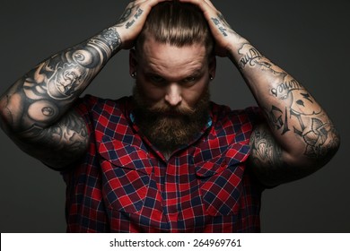 Man With Tattoo On Arms Posing In Studio. Isolated On Grey.