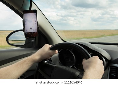 man taxi driver driving  car, looking at the road map in gps Navigator smartphone