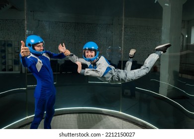 A Man Teaches A Woman How To Fly In A Wind Tunnel. Free Fall Simulator.