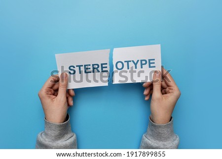 A man tears up a paper with the inscription: stereotype. A symbol of breaking stereotypes in life