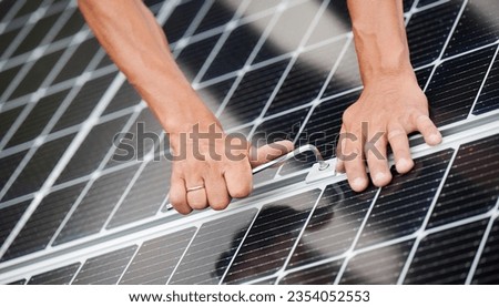 Man technician mounting photovoltaic solar moduls on roof of house. Close up of engineer installing solar panel system outdoors, tightening with hex key. Concept of alternative and renewable energy.