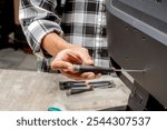 Man technician repairing television with a screwdriver. Service, maintenance or repairing concept