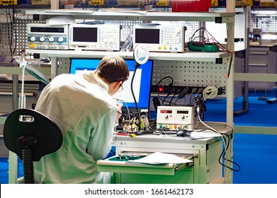 Man In A Technology Laboratory. Man With A Soldering Iron At The Desk. Concept - Modern Inventor. Workplace Robotics. Designing Robots. Robotics Workshop. Industrial Robotics Designer.