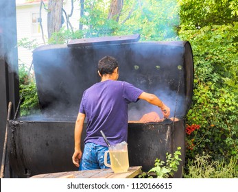 Man Tending Barbecue Pit