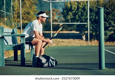 Man, tennis and waiting with racket for sport, game or match on bench at outdoor court. Young, male person or athlete with bat for break, rest or half time in competition, tournament or practice - Powered by Shutterstock