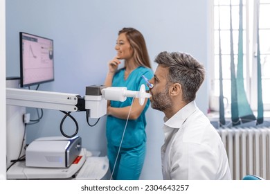 Man testing breathing function by spirometry. Diagnosis of respiratory function in pulmonary disease