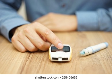 Man Testing Glucose Level With A Digital Glucometer, Diabetes Treatment