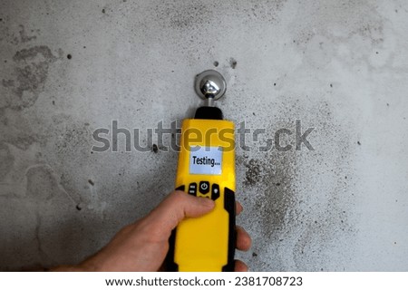 Man testing the humidity in a wall with a moisture meter.