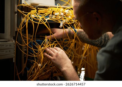 Man Testing Network Cables in Server Room