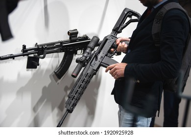 A Man Tests Firearms In A Specialty Store. Samples Of Machine Guns On The Showcase Of The Trading Network. Close-up. Unrecognizable Person