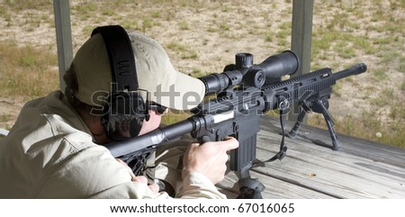man that is behind the trigger of an assault rifle