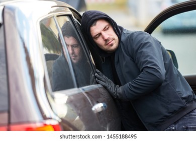 Man As A Thief At The Open Door Of A Car