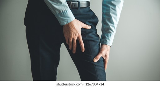man thigh pain from cramp on gray background