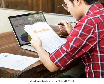 Man thinking about graph and working on wooden desk at coffee shop in the morning