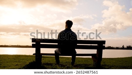 Man, thinking or back view with sunset on bench at lake for daydreaming, memory or break in nature. Male person, relax and fresh air with cloudy sky for rest, contemplating or travel at river or pond