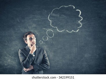 A man thinking in front of the blackboard - Shutterstock ID 342199151