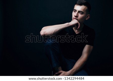Man with thoughtfull pose. Guy thinking about something. Male model sitting on chair