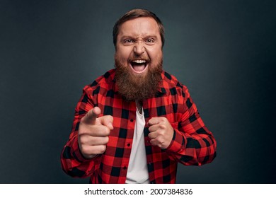 Man threatening person with angry outraged expression, lose temper standing distressed, pointing camera accuse someone, blame girlfriend, having argument and shouting, grey background.