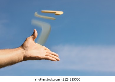 Man Throwing Boomerang Against Blue Sky, Closeup