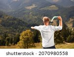 Man throwing boomerang in mountains on sunny day, back view. Space for text