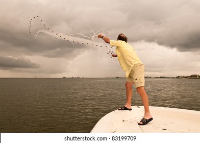 A Man Throwing A Cast Net Off A Bow Of A Boat