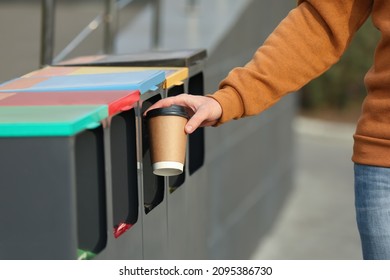 Man throwing coffee cup into sorting bin outdoors, closeup - Shutterstock ID 2095386730