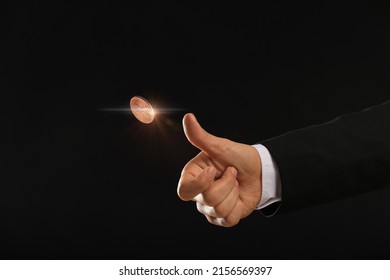 Man throwing coin on black background, closeup. Making decision - Shutterstock ID 2156569397