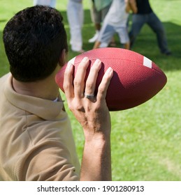 Man Throwing Football To Friends