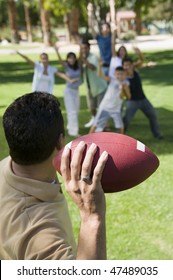 Man Throwing Football To Friends