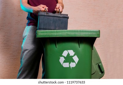 Man Throwing Old Car Battery In Recycle Bin. E-waste Concept , Toxic Waste