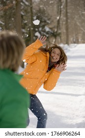 Man Throwing Snowball At Woman