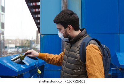 Man throwing sorted garbage during coronavirus or covid 19 quarantine. Man in protective mask with glass bottle. Trash can for separate garbage collection. Garbage divided.