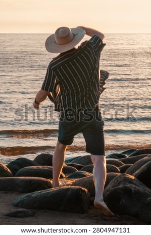 Man Throwing Stone into the Sea at Sunset, Letting Go and New Beginning Concept