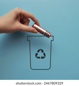 A man throws a battery into a dumpster. Sorting and recycling of batteries
