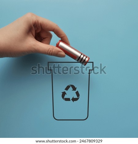 A man throws a battery into a dumpster. Sorting and recycling of batteries