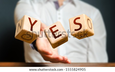 A man throws cubes with letters and makes up the word YES. Agreement and acceptance, answer the question. Courage and irresistibility, zeal forwards, consent. Confirmation and acceptance, approval