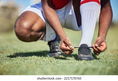 Man tie football shoes lace on soccer field, athlete ready for sports training in Portugal and exercise on grass stadium. Young person in uniform on pitch, prepare for game and socks with boots - Powered by Shutterstock