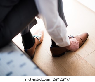 Man tie up shoelace on the parquet floor.Man in formalwear tying up shoe lace of a brown leather elegant shoe. Low section view image of groom tying up brown leather shoes. - Powered by Shutterstock